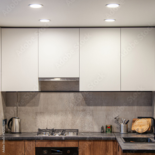 Modern kitchen interior lightning with cement wall and gas coocker photo