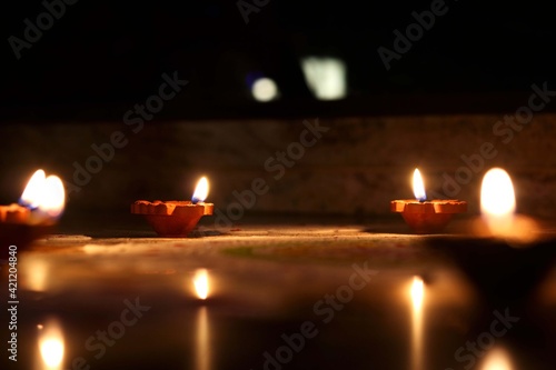 View of clay diyas (Indian clay oil lamp) near rangoli during festive of Diwali