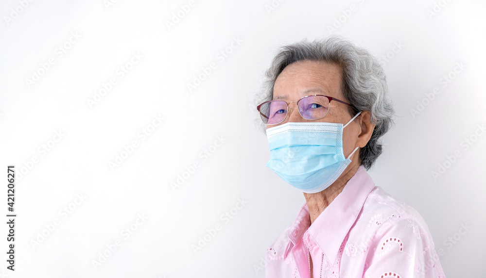 Gray-haired Asian elderly woman wear pink clothes and wear masks to protect against disease or COVID 19 Gray-haired Asian elderly woman wear pink clothes and wear masks to protect against disease or COVID 19