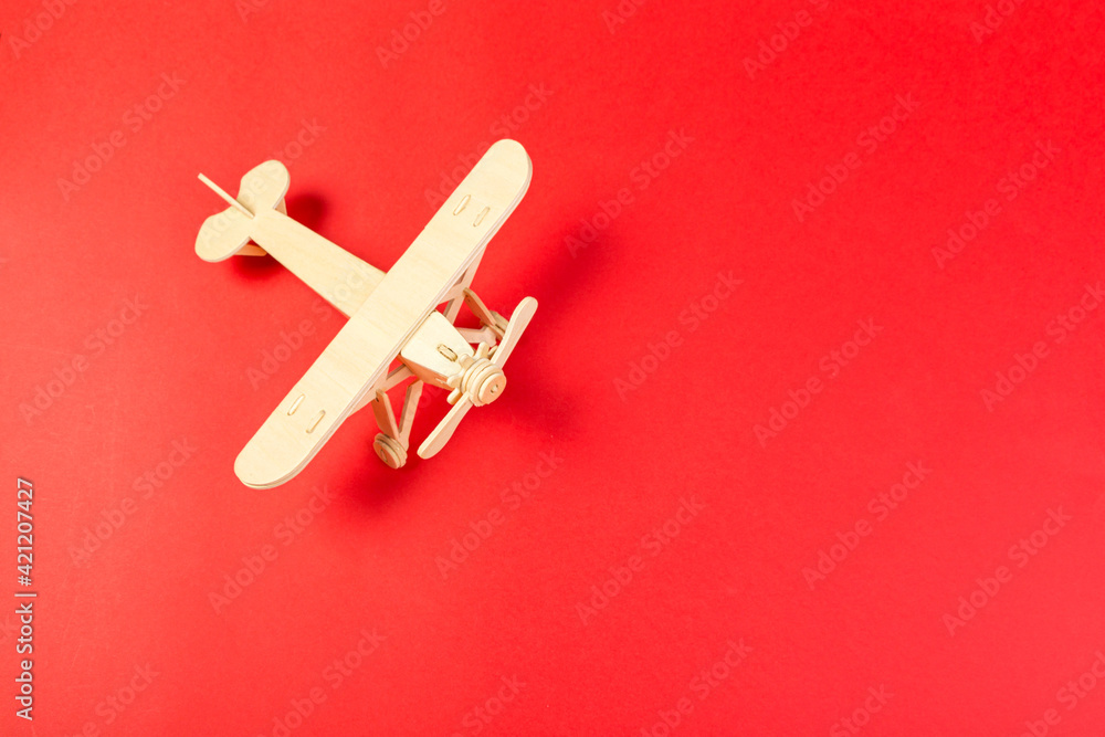 wooden model of a passenger plane with on a red background. tourism and travel wooden model of a passenger plane with on a red background. tourism and travel