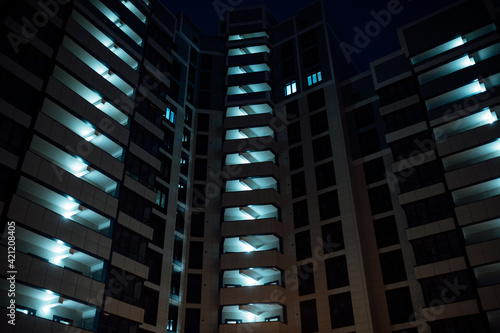 many identical windows in the building have lights on at night