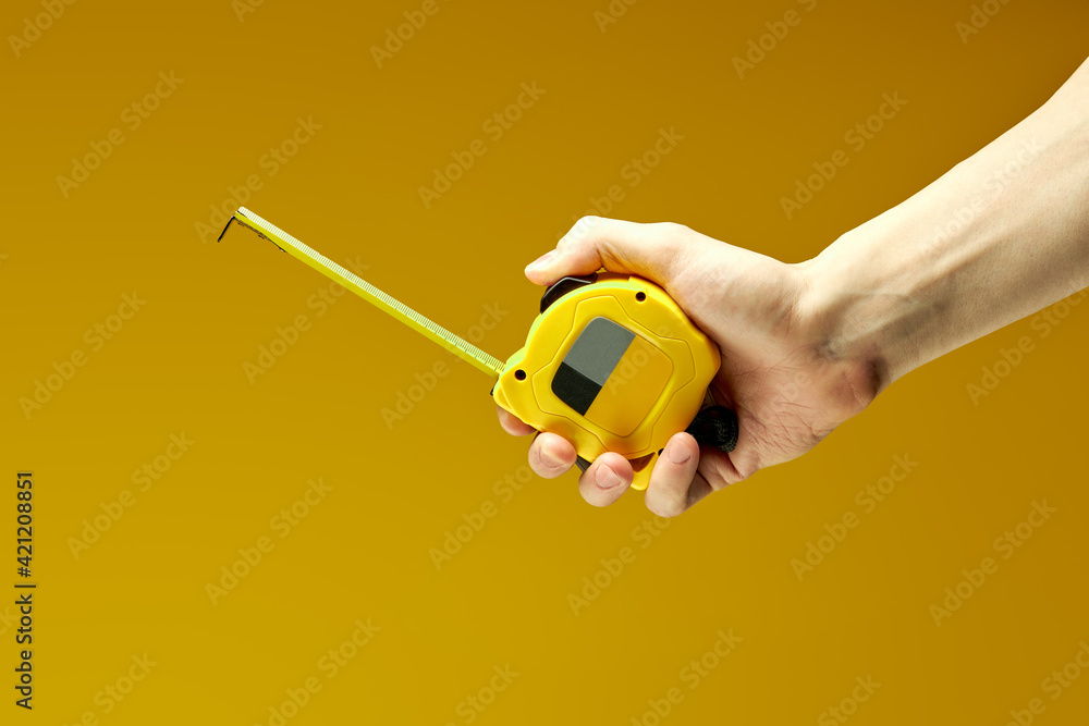Measuring tape in hands of cropped person making measurements
