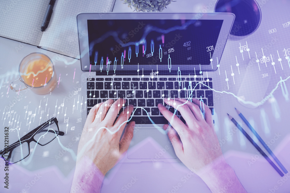 Double exposure of man's hands typing over laptop keyboard and forex chart hologram drawing. Top view. Financial markets concept. Double exposure of man's hands typing over laptop keyboard and forex chart hologram drawing. Top view. Financial markets concept.