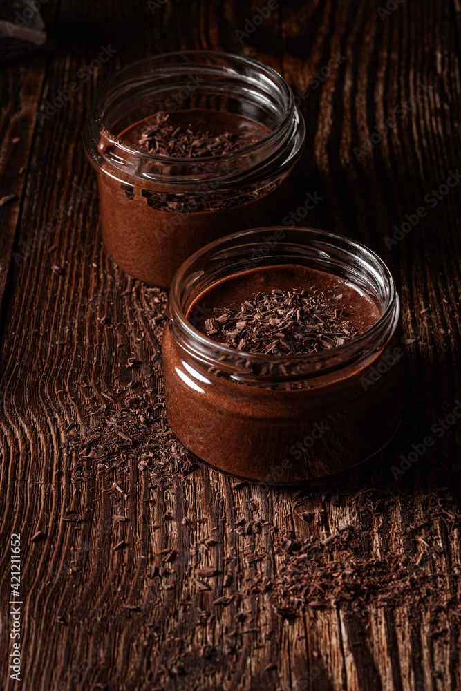 Homemade dark chocolate mousse in rural jars on rustic wood table Homemade dark chocolate mousse in rural jars on rustic wood table
