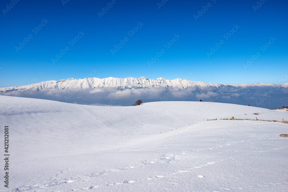 Mountain Range of Monte Baldo and Adamello in winter with snow,  view from the Lessinia Plateau (Altopiano della Lessinia) Verona. Veneto and Trentino Alto Adige, Italy, Europe.