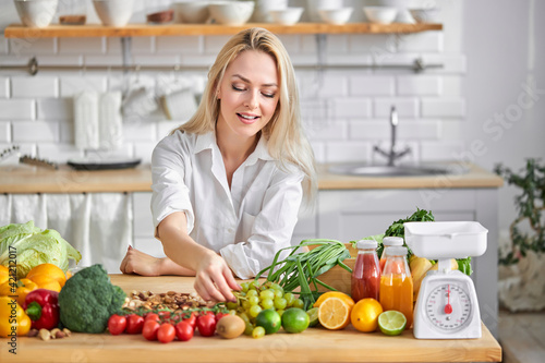 woman food blogger engaged in process of preparing food in kitchen from fresh vegetables