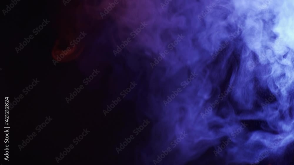 Thick colorful smoke of blue, pink, red on a black isolated background. Background from the smoke of vape Thick colorful smoke of blue, pink, red on a black isolated background. Background from the smoke of vape