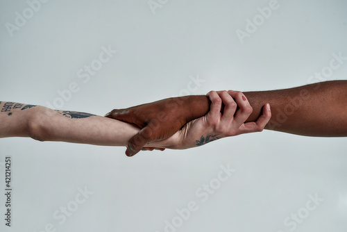 Fotografia Multiracial couple holding hands in lock shape