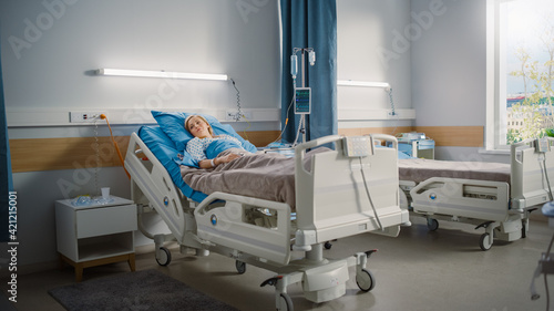 Hospital Ward  Beautiful Caucasian Female Patient Resting Peacefully in Bed  Recovering after Successful Surgery. Spaceous Light Room with Window with a Sunny View. Modern Equipment Clinic