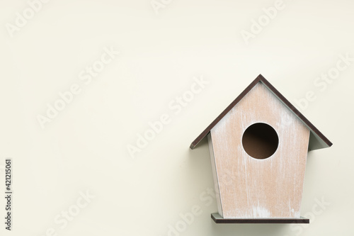 Beautiful bird house on beige background, top view. Space for text
