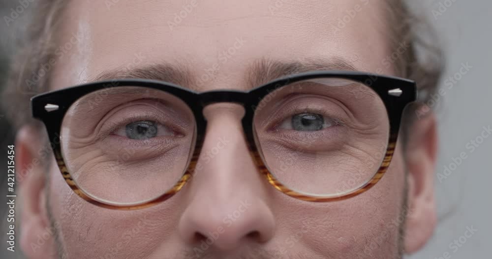 Close up of Man beautiful Blue Eyes in Eyeglasses. Caucasian Young Successful Man with Azure Eyes looking at the Camera. Slow - Motion. Attractive Business Appearance. Close up of Man beautiful Blue Eyes in Eyeglasses. Caucasian Young Successful Man with Azure Eyes looking at the Camera. Slow - Motion. Attractive Business Appearance.