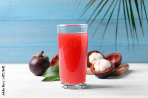 Delicious fresh mangosteen juice in glass on white table