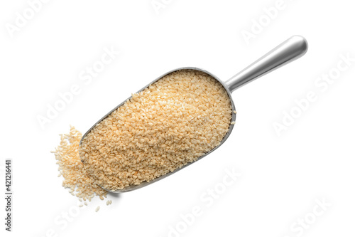 Metal scoop with sesame seeds on white background, top view photo