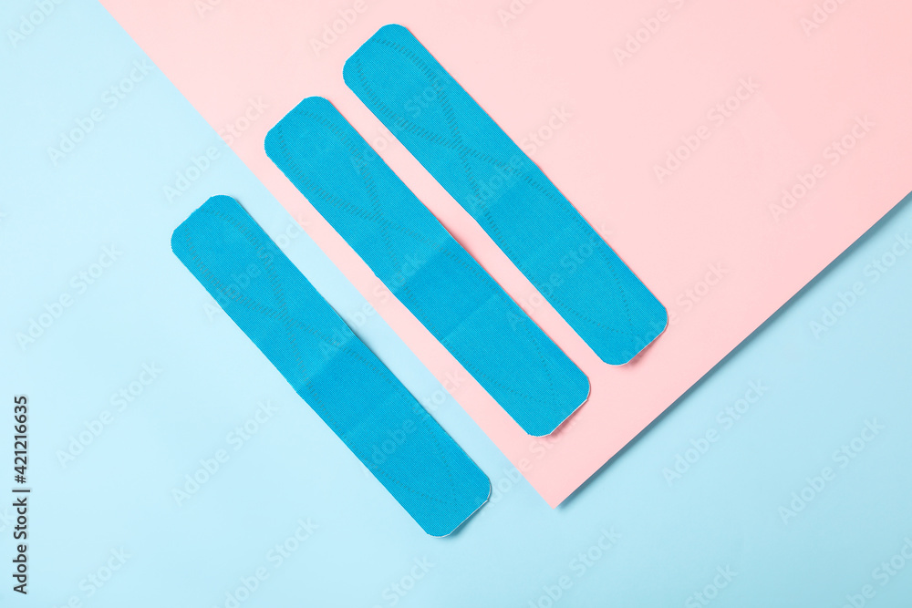 Bright kinesio tape pieces on color background, flat lay Bright kinesio tape pieces on color background, flat lay
