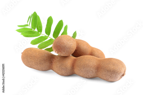 Delicious ripe tamarinds with leaves on white background. Exotic fruit