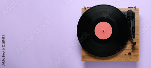 Modern turntable with vinyl record on light background, top view