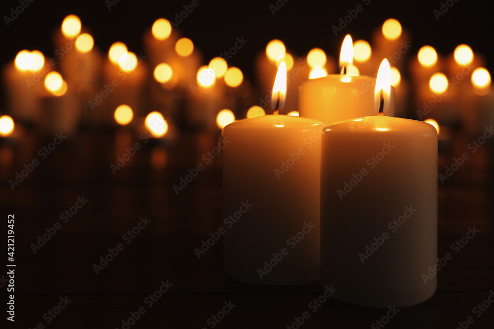 Burning candles on dark table, space for text. Memory day Burning candles on dark table, space for text. Memory day