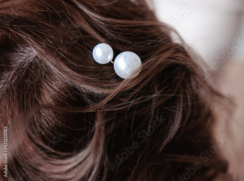 the hairdresser puts the girl's hair, jewelry made of pearls