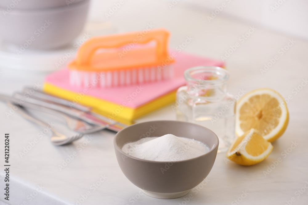 Baking soda, lemon and vinegar on white table. Eco friendly detergents Baking soda, lemon and vinegar on white table. Eco friendly detergents