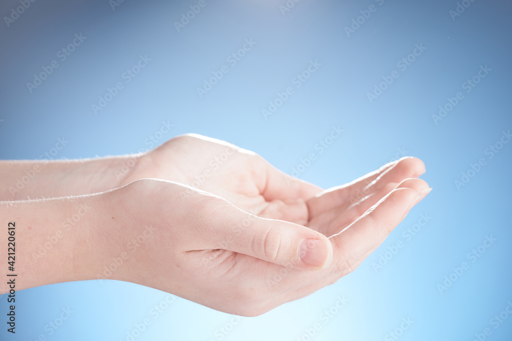 Close-up of beautiful woman hands, palms up. Isolated on blue background. Photo from copy space. Close-up of beautiful woman hands, palms up. Isolated on blue background. Photo from copy space.