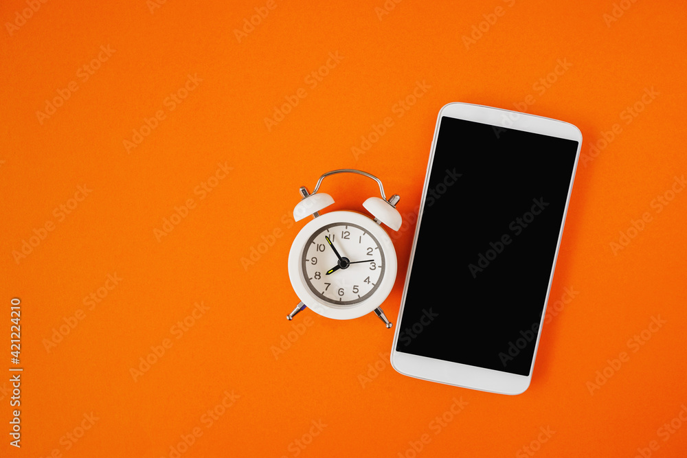 white alarm clock and mobile phone with clipping part on touch screen on  grunge orange background for technology , time passing concept Stock Photo  | Adobe Stock