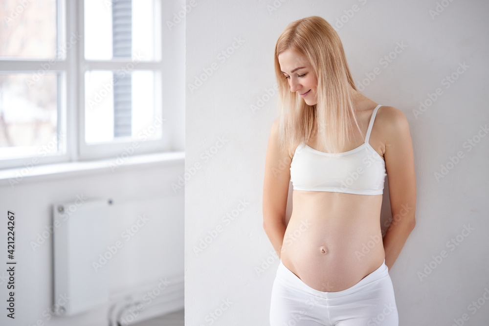 Obraz premium beautiful blonde pregnant woman stand having rest posing