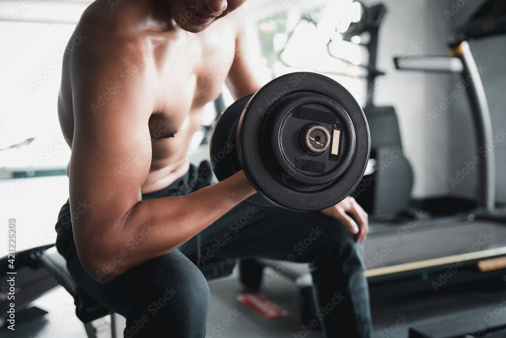 Muscular bodybuilder guy lifting weights in gym. Muscular bodybuilder guy lifting weights in gym.