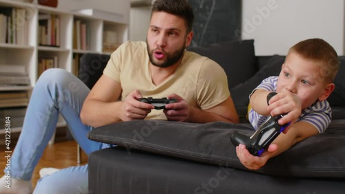 father playing video games with his son at home	
