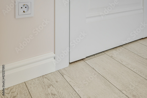 Detail of corner flooring with intricate crown molding and plinth. photo