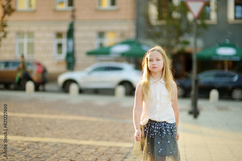 Cute young girl sightseeing on the streets of Vilnius, Lithuania on warm and sunny summer day.