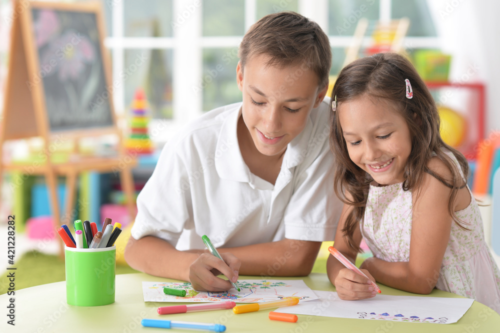 Smiling brother and sister drawing together Smiling brother and sister drawing together