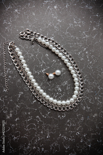 pearl jewelry and chains for girls on a marble background