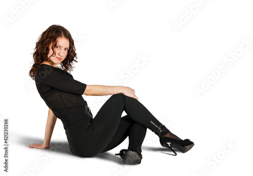 young beautiful woman in black suit posing sitting on the floor