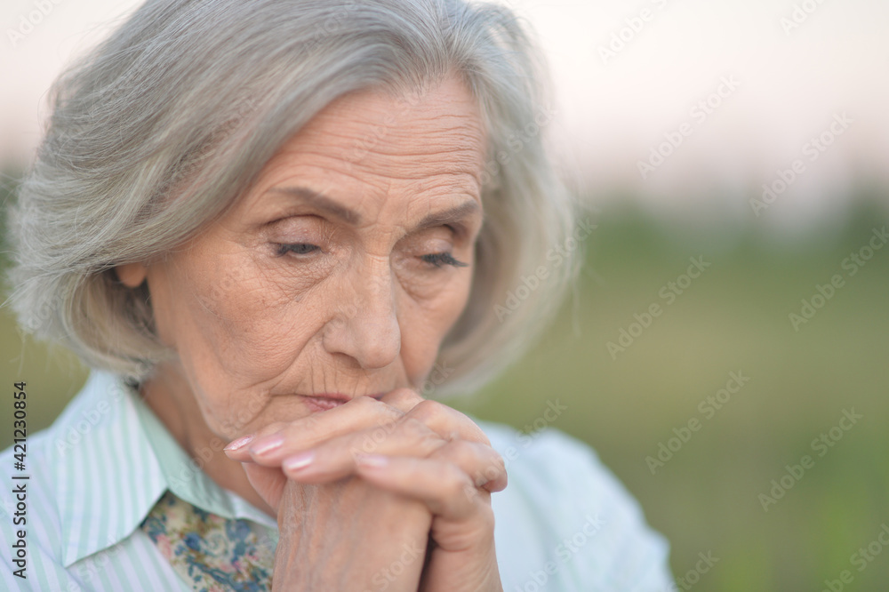 Sad senior beautiful woman in spring park Sad senior beautiful woman in spring park