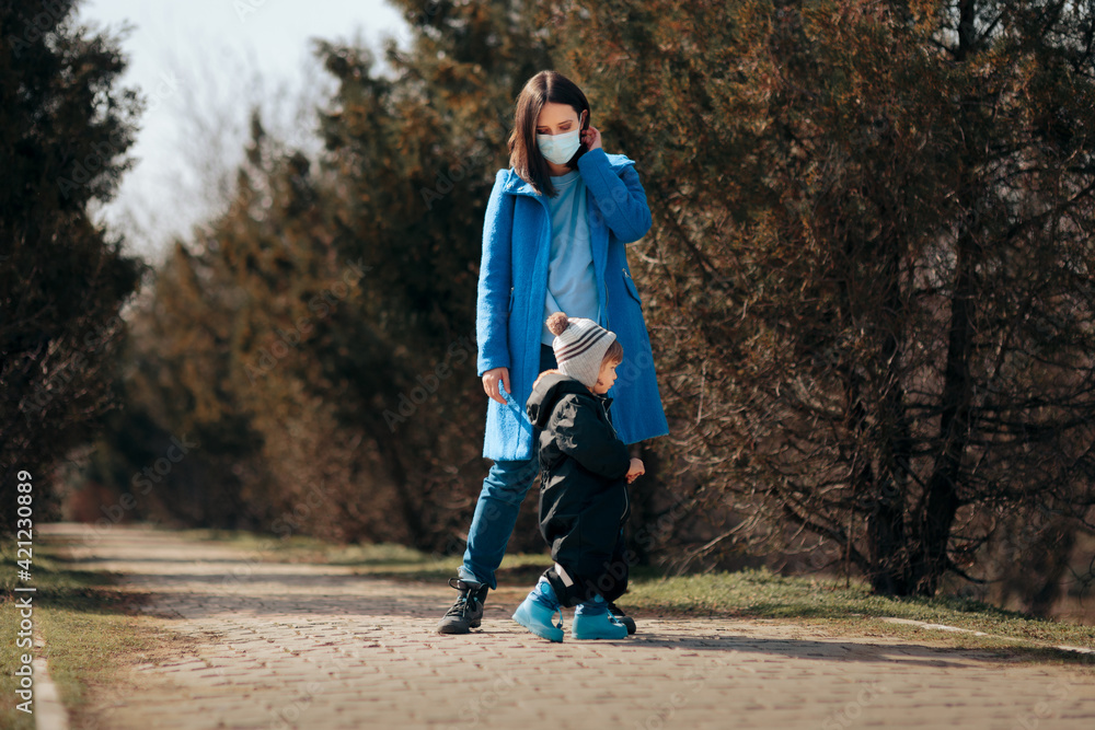 Mother Wearing Medical Mask Supervising Child Playing Outdoors