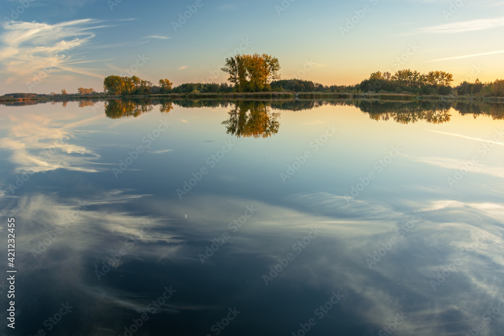 Fototapeta premium Reflection of white clouds in the water of a calm lake