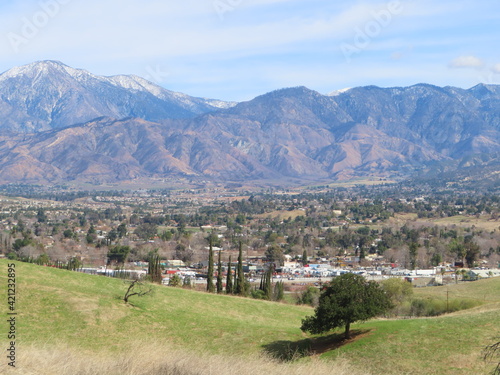 Yucaipa, California, City Valley from a Dry Hill with Huge Mountains in the Background and a Cloudy Sky Above photo