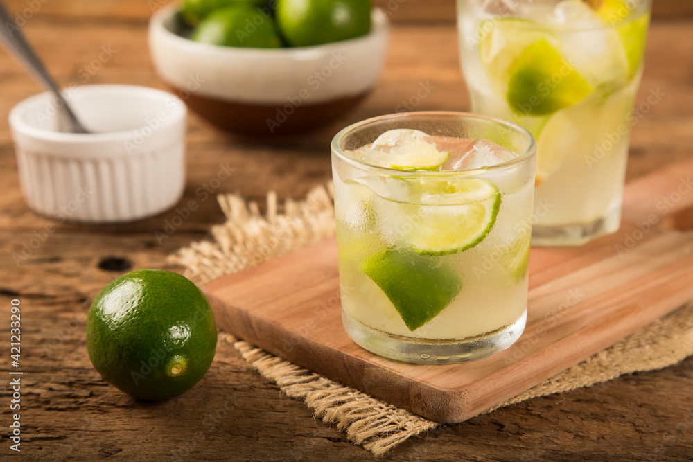Brazilian Caipirinha. Cachaça drink with lemon, on rustic wooden background. Brazilian Caipirinha. Cachaça drink with lemon, on rustic wooden background.