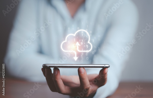 Businessman holding virtual cloud computing on smartphone to transfer data information and upload download application. Technology transformation concept. photo