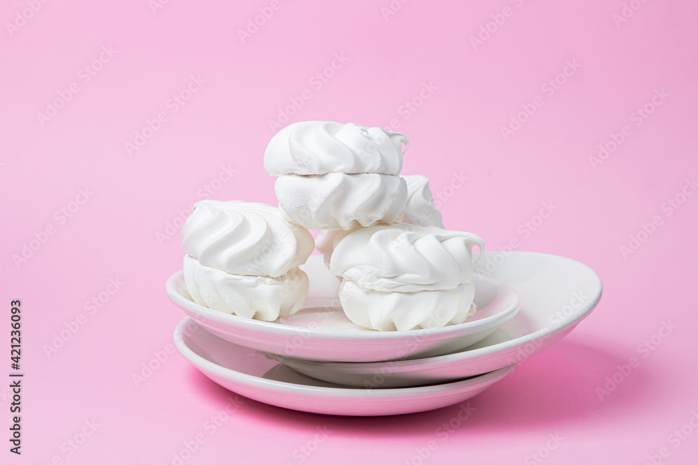 White marshmallow on a pink background. White marshmallow on a white plate. Light dessert White marshmallow on a pink background. White marshmallow on a white plate. Light dessert