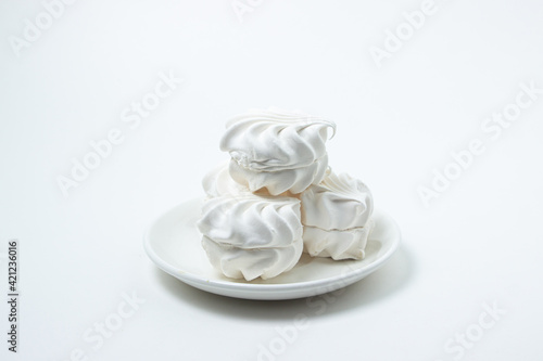 Marshmallow on a white background. White marshmallow on a white plate. Light dessert