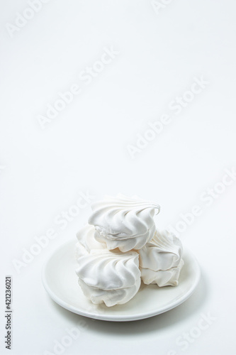 Marshmallow on a white background. White marshmallow on a white plate. Light dessert