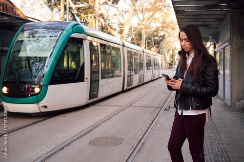 woman consulting telephone at the streetcar stop