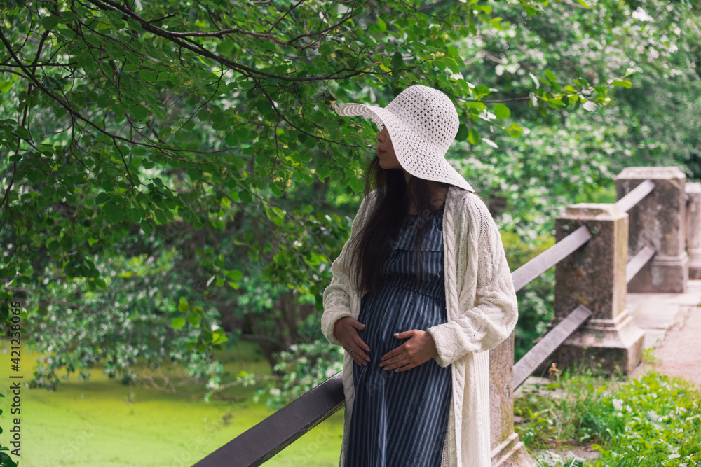 Obraz premium Young asian pregnant woman in white hat