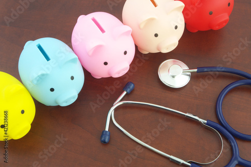 Cost of medical examination and insurance concept piggy bank and stethoscope on table, saving money concept 