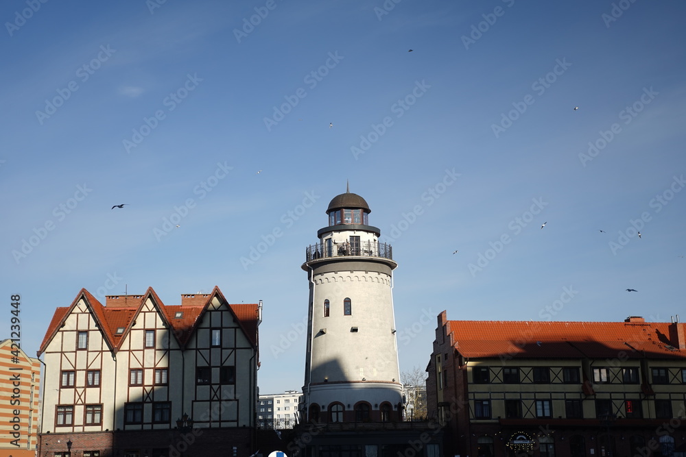an old restored lighthouse stands in the middle of houses in the center of the city of Kaliningrad