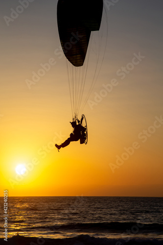 Israel, Haifa,  - March 13, 2021: paraglider flying with paramotor on air on sunset
