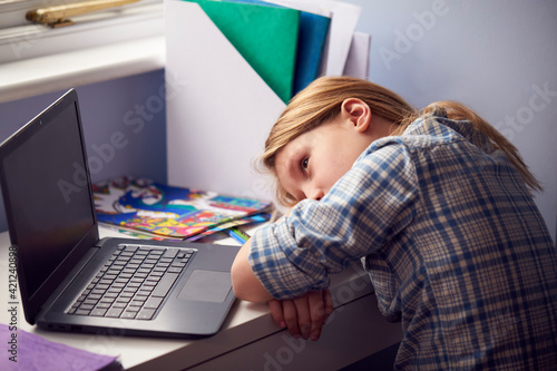 Fotografia Bored Girl Sitting Lying Head On Desk Whilst Home-Schooling With Laptop During H