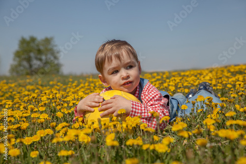 A kid laying down with his soccer ball in the middle of a field