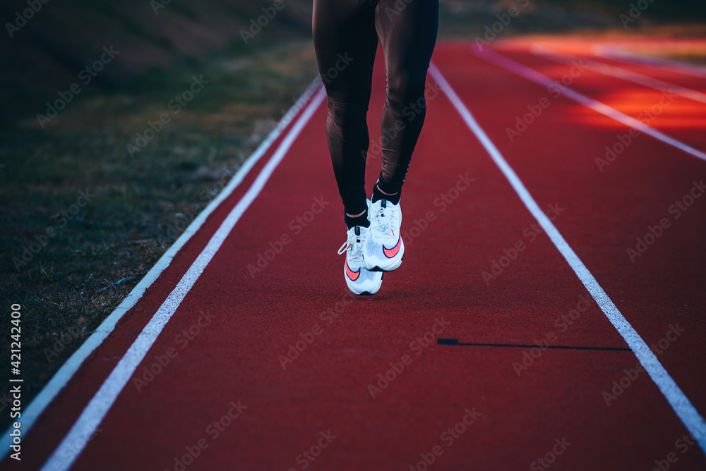 TOKYO, JAPAN, MARCH 18. 2021: Nike running shoes NEXT%. Controversial athletics shoe on legs of athlete running on the road. Official white shoe for Tokyo Olympics 2020 marathon Stock Photo | Adobe Stock
